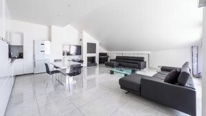 Un appartement moderne comprenant un coin repas, un salon et une cuisine.