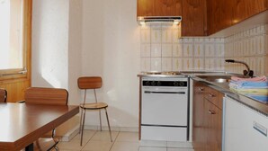 Une cuisine de taille réduite, dotée de meubles en bois, d’une cuisinière et d’un évier.