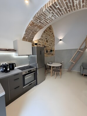 Una cocina moderna con horno, refrigerador y cafetera integrados.
