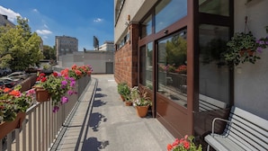 Un balcon agrémenté de plantes en pot et d’un banc.