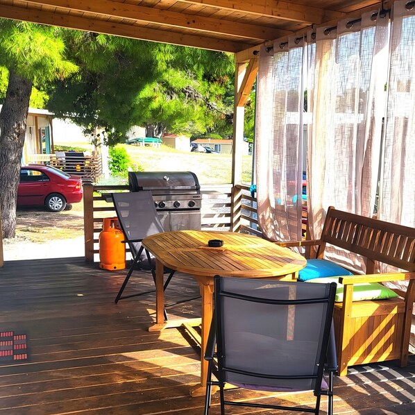 A covered outdoor area with a grill, chairs, and a table. - Mobile Home 'Kućica Br. 2 Zelena' with Sea View, Wi-Fi and Air Conditioning (Živogošće)