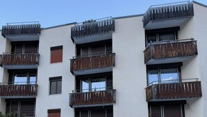 En flervåningsbyggnad med balkonger, en stenmur och en skylt med texten ”PARSENNRESIDENZ”.