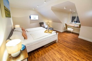 A bedroom with a bed, bedside table, lamp, chair, desk, and window. - Vacation at Schwedenhus2 in Wangerooge (Wangerooge)