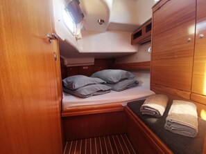 A compact cabin with a bunk bed, a small table, and a storage cabinet. - Sun-Kissed Sailing Adventure in Sibenik, Croatia (Primošten)