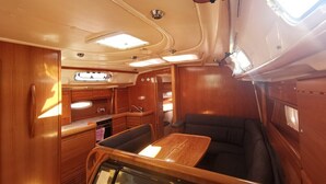 A compact kitchen with wooden cabinets, a countertop, and a built-in stove. - Sun-Kissed Sailing Adventure in Sibenik, Croatia (Primošten)