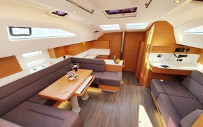 A compact interior with a dining area, seating, and a kitchenette. - Sun-Kissed Sailing Adventure in Zadar, Croatia (Biograd na moru)
