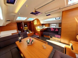 A modern interior with a dining area, seating, and a kitchen. - Sun-Kissed Sailing Adventure in Zadar, Croatia (Biograd na moru)