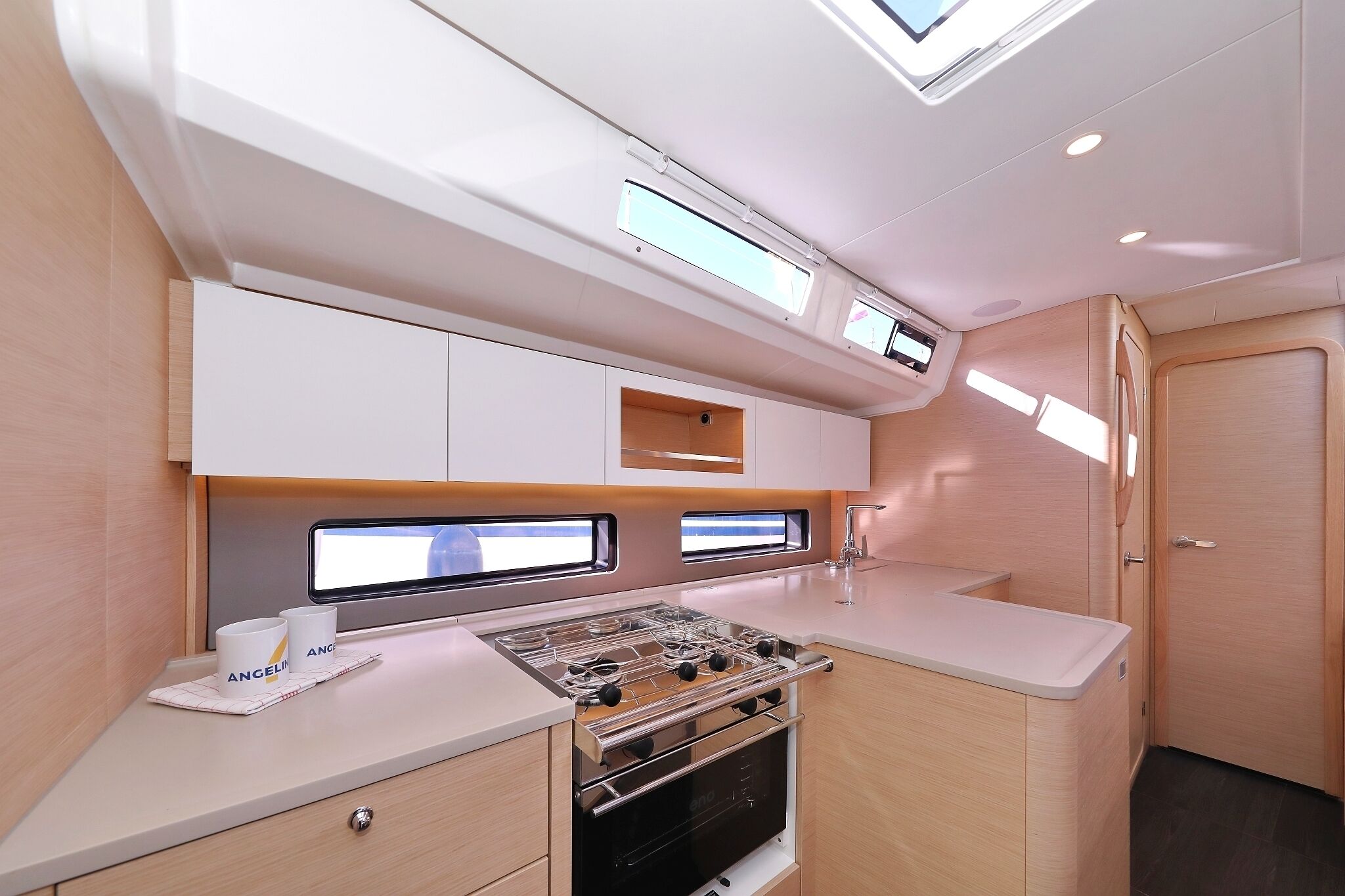 Una cocina compacta con estufa, dos ventanas y una puerta.