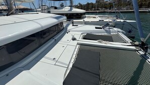 Marina com vários iates atracados, apresentando uma área de deck coberta e uma vista desimpedida dos edifícios ao redor.