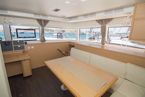 Una cabaña con una cama, un escritorio y una ventana con vistas al puerto deportivo.