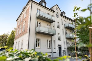 A multi-story building with balconies, a brick facade, and a flat roof. - Stadt Land Fluss Studio Apartment '4' in Regensburg (Regensburg)