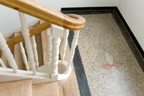 Eine Holztreppe mit weißen Spindeln und einem Holgeländer.