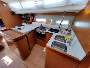 A compact galley with a stove, sink, and storage cabinets. - Sun-Kissed Sailing Adventure in Istria, Croatia (Pula)