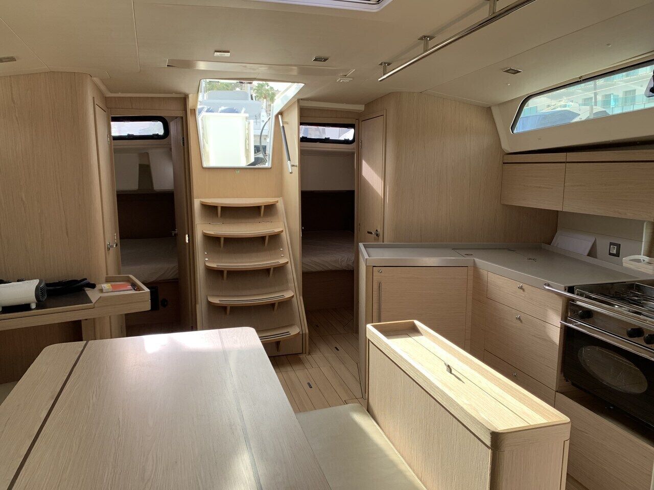 Un intérieur de camping-car compact comprenant un coin cuisine, un lit et un petit espace repas.