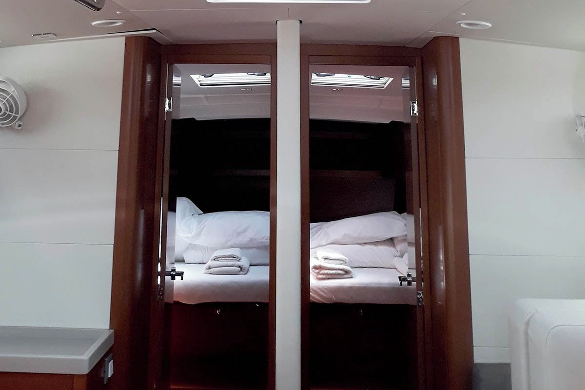 A hotel room with a double bed, a bedside table, and a wardrobe with a mirror.