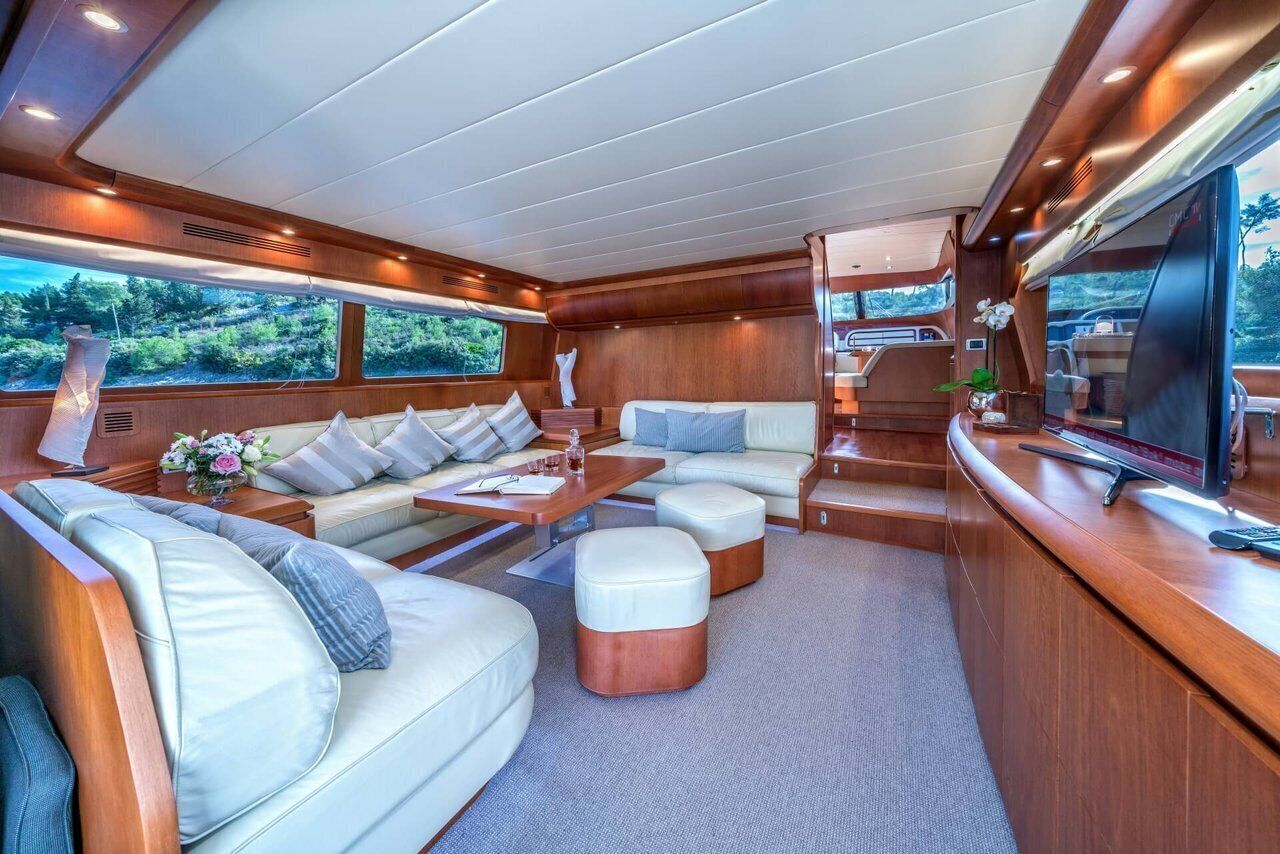 A luxurious interior with a sofa set, ottomans, a coffee table, and a television.