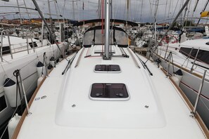 A marina with multiple boats docked, a central mast, and a white deck with metal railings. - Sibenik Sun and Beach Sailing Extravaganza: A Croatian Coastal Adventure (Vodice)