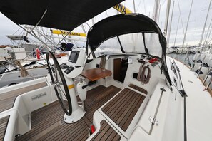 A boat deck with a steering wheel, control panel, and seating area. - Sibenik Sun and Beach Sailing Extravaganza: A Croatian Coastal Adventure (Vodice)