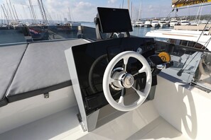 A boat's helm station with a steering wheel, control panel, and a monitor. - Sun-Kissed Sailing Adventure in Zadar, Croatia (Biograd na moru)