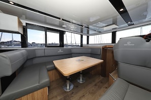 A modern interior with a wooden table and grey upholstered seating. - Sun-Kissed Sailing Adventure in Zadar, Croatia (Biograd na moru)