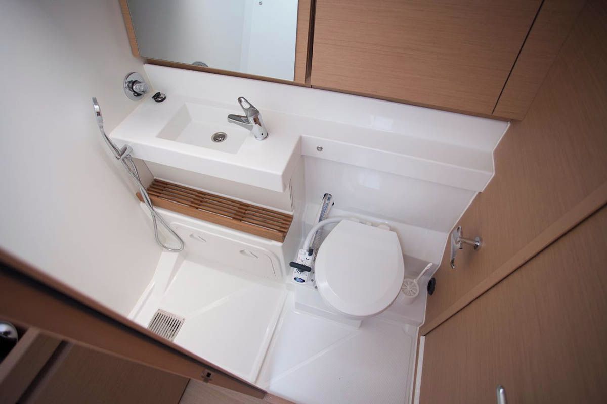Een kleine badkamer met een wastafel, toilet en spiegel.