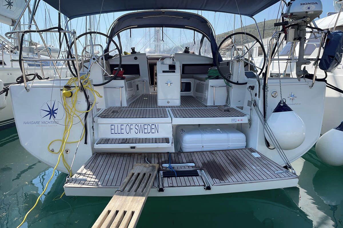 Un yate con cubierta protegida, una placa de identificación que dice 'Ellen of Sweden' y un motor visible.