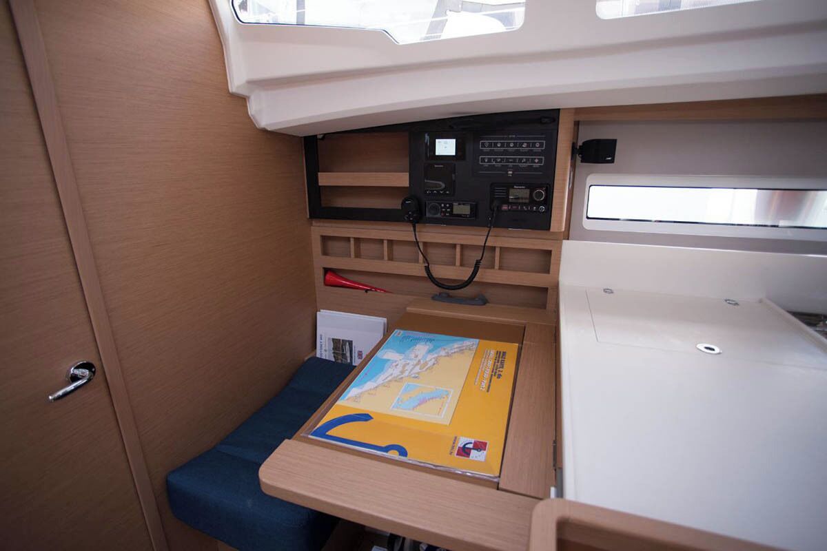 A compact interior with a control panel, storage compartments, and a small seating area.