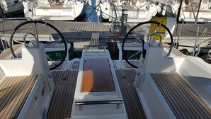 Convés de barco com um leme, painel de controle e convés de madeira.