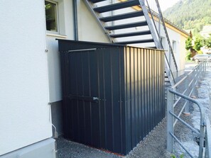A black metal gate, a staircase, and a building with a window.