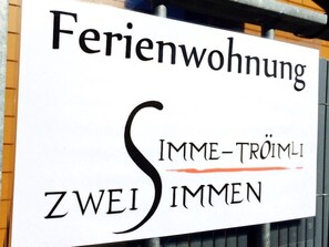 A sign with the text 'Ferienwohnung' and 'ZWEI SIMMEN' indicating a two-room apartment.