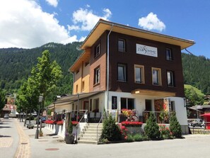 A two-story building with a sign reading 'ZUR SIMME' and a restaurant sign below.