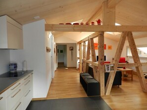 A modern kitchen with white cabinets and a black countertop. - Simme-Tröimli Appartement/Fewo, Dusche, WC 4-Bettwohnung by Interhome (Zweisimmen)