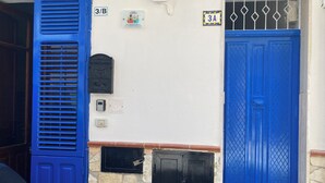 A building with a blue door, a blue window shutter, and a stone wall. - Blue Dream Balestrate (Balestrate)