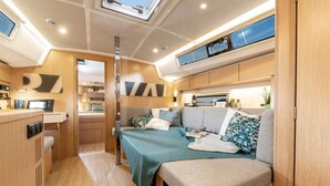 Un interior compacto y bien iluminado, con kitchenette, cama con vistas y un pequeño comedor.