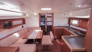Un interior funcional con comedor, asientos, kitchenette y armario.
