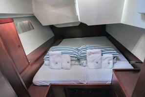 A compact cabin with a single bed, a wooden wardrobe, and a small storage area. - Sun-kissed Sailing Adventure in Split-Dalmatia, Croatia (Seget Donji)
