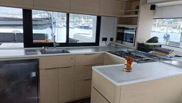 Una cocina moderna con un ventanal grande, electrodomésticos de acero inoxidable y armarios de madera.