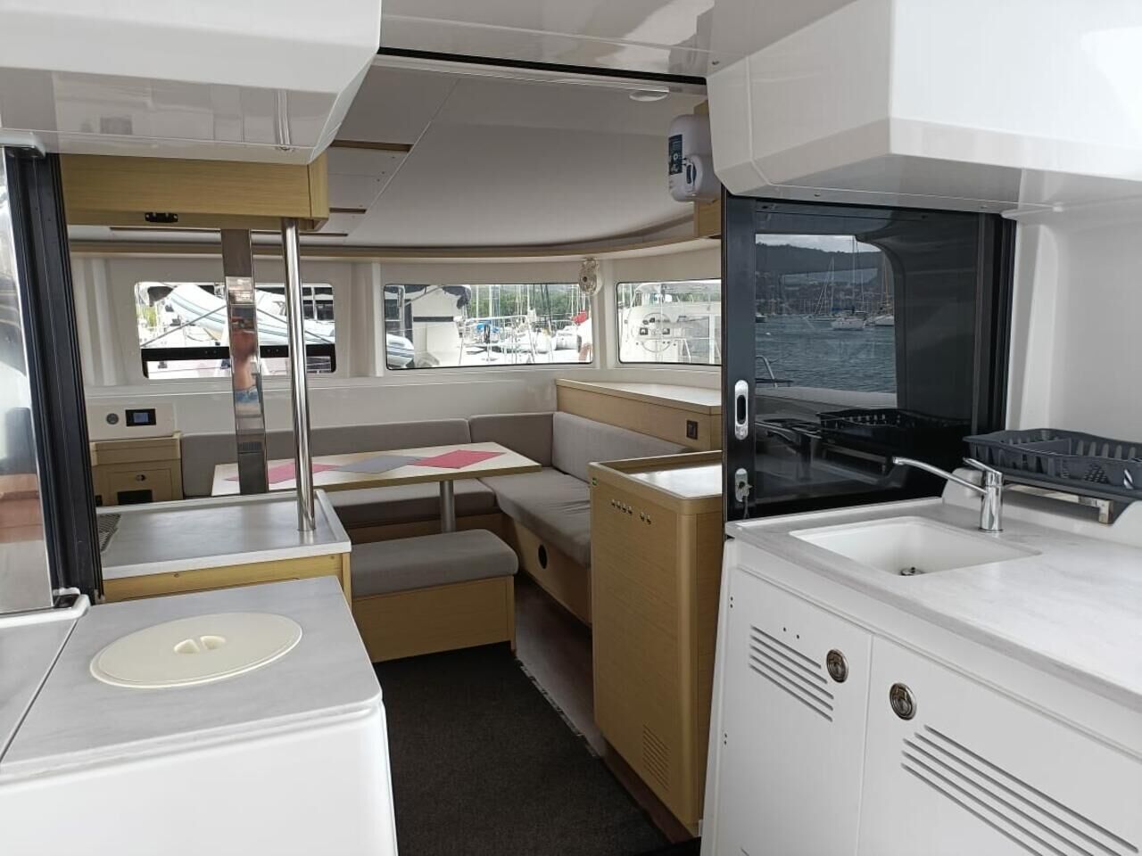 Een compacte keuken met een fornuis, spoelbak en een klein eethoekje met een bankje en tafel.