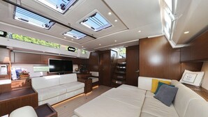 A modern interior with a sofa, TV, and wooden cabinets. - Sun-Kissed Sailing Adventure in Split, Croatia (Split)