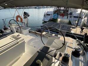 Das Deck eines Bootes mit Steuerrad, Steuerstand und diverser Navigationstechnik.