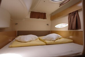 A compact cabin with a single bed, a small window, and a headboard. - Sun-Kissed Sailing Adventure in Northern Croatia (Punat)