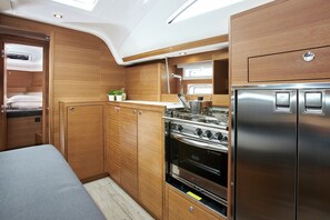 Une cuisine de taille réduite, dotée de meubles en bois, d’une cuisinière en acier inoxydable et d’un réfrigérateur.