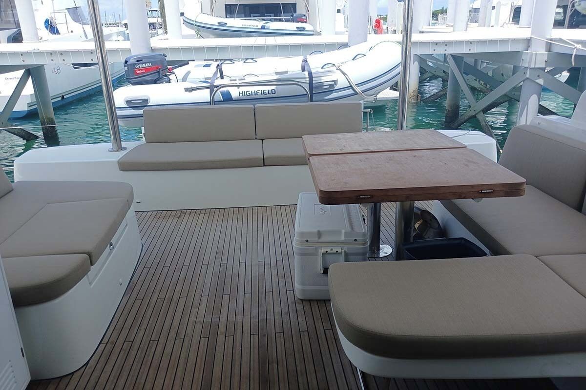 Convés de barco com assentos, uma mesa e um motor Yamaha.