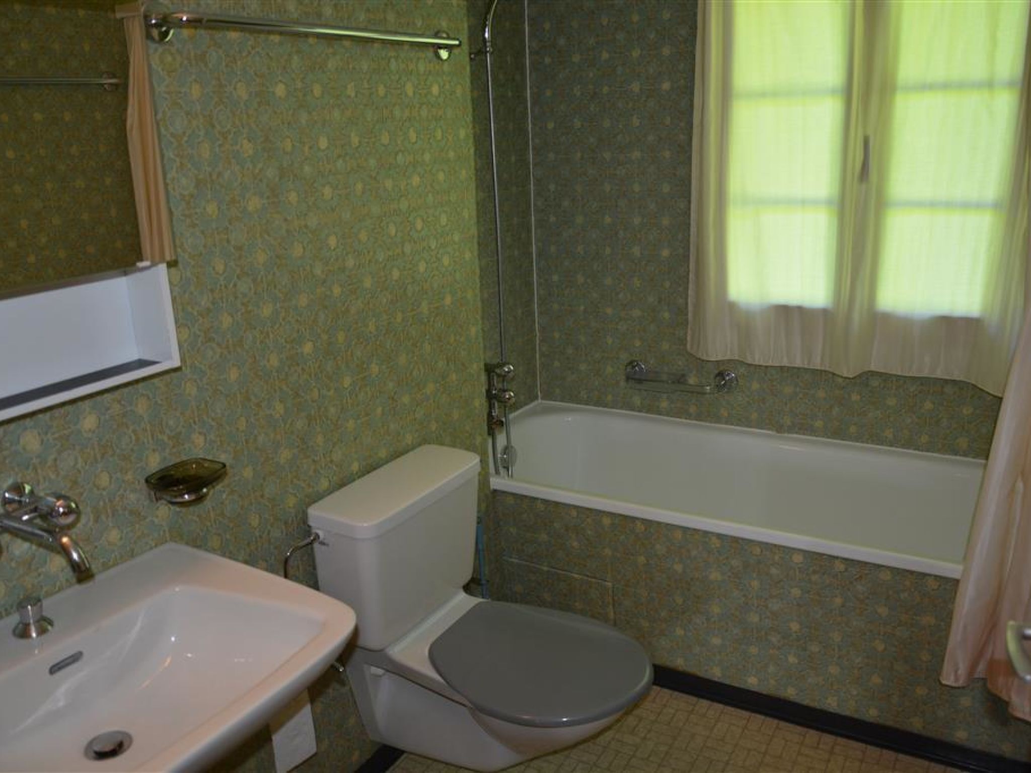 Un baño con lavamanos, inodoro y bañera.