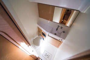 Een kleine badkamer met een wastafel, spiegel en toilet.