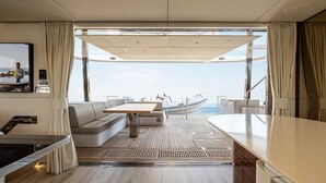 A yacht interior with a sofa, table, and a view of the sea. - Sun-Kissed Sailing Adventure in Split, Croatia (Kaštel Gomilica)