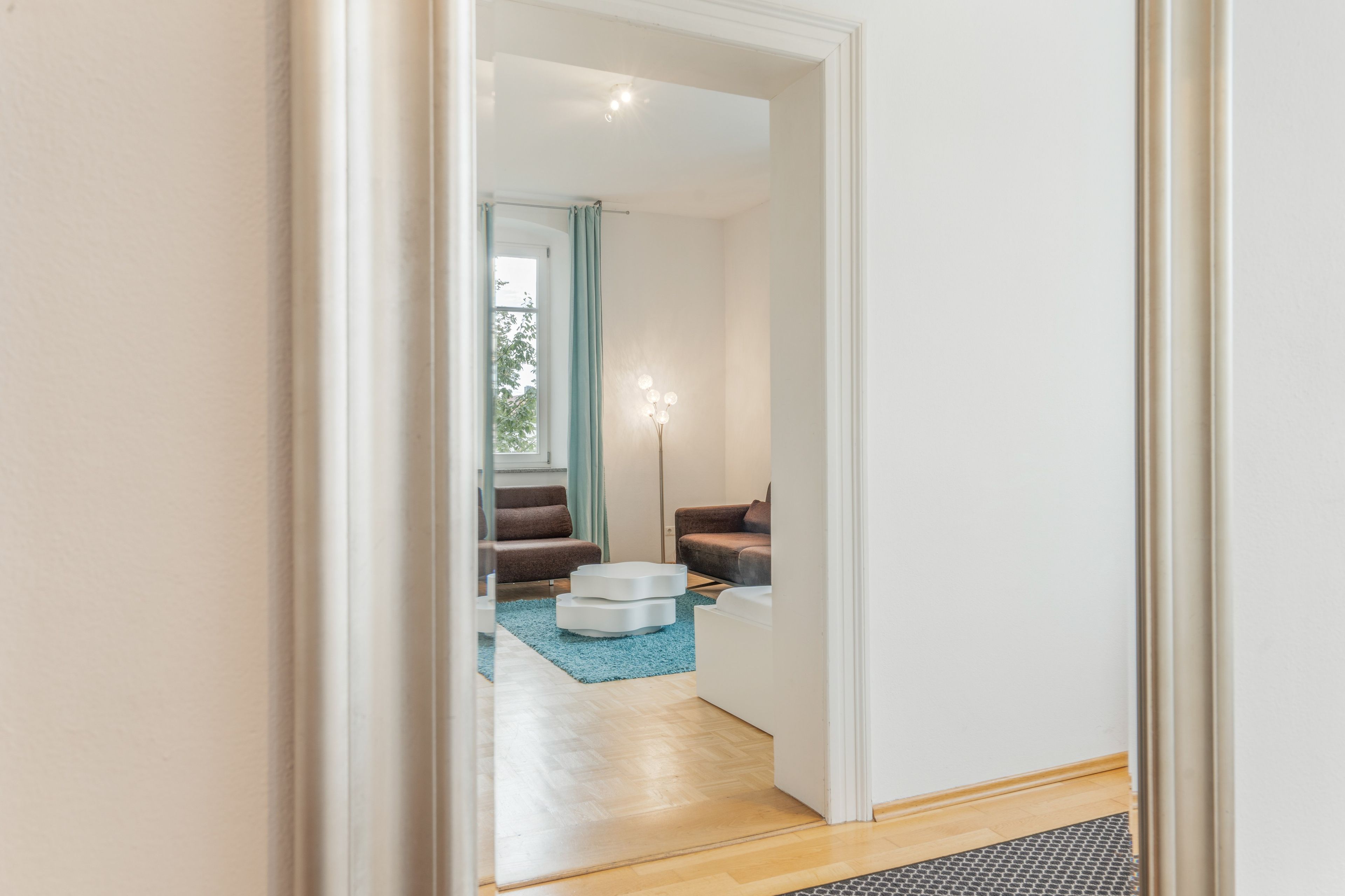 Un salon moderne avec un canapé, une table basse et une lampe.