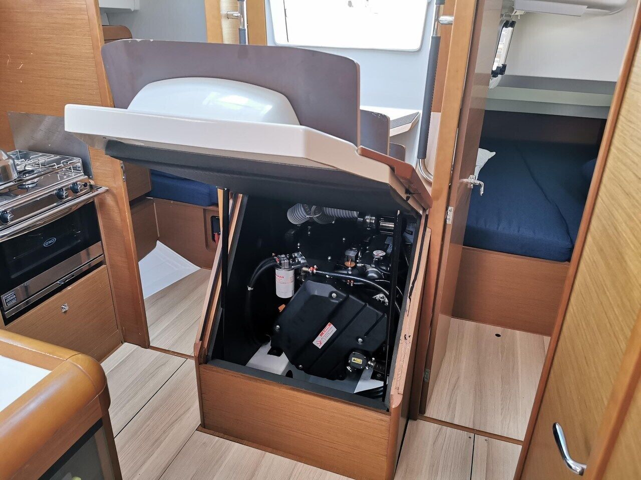 A compact kitchenette with a stove, a sink, and a bed in a small cabin.