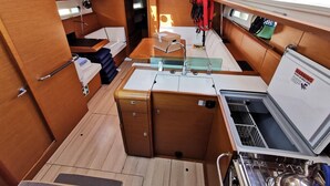 A compact galley with a sink, storage cabinets, and a compact refrigerator. - Sun-Kissed Sailing Adventure in Istria, Croatia (Pula)