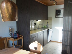 A compact kitchen with a sink, cabinets, and a countertop. - Malgré-tout Appartement/Fewo, Dusche oder Bad, WC, 1 Schlafraum 2-Bettwohnung by Interhome (Gstaad)